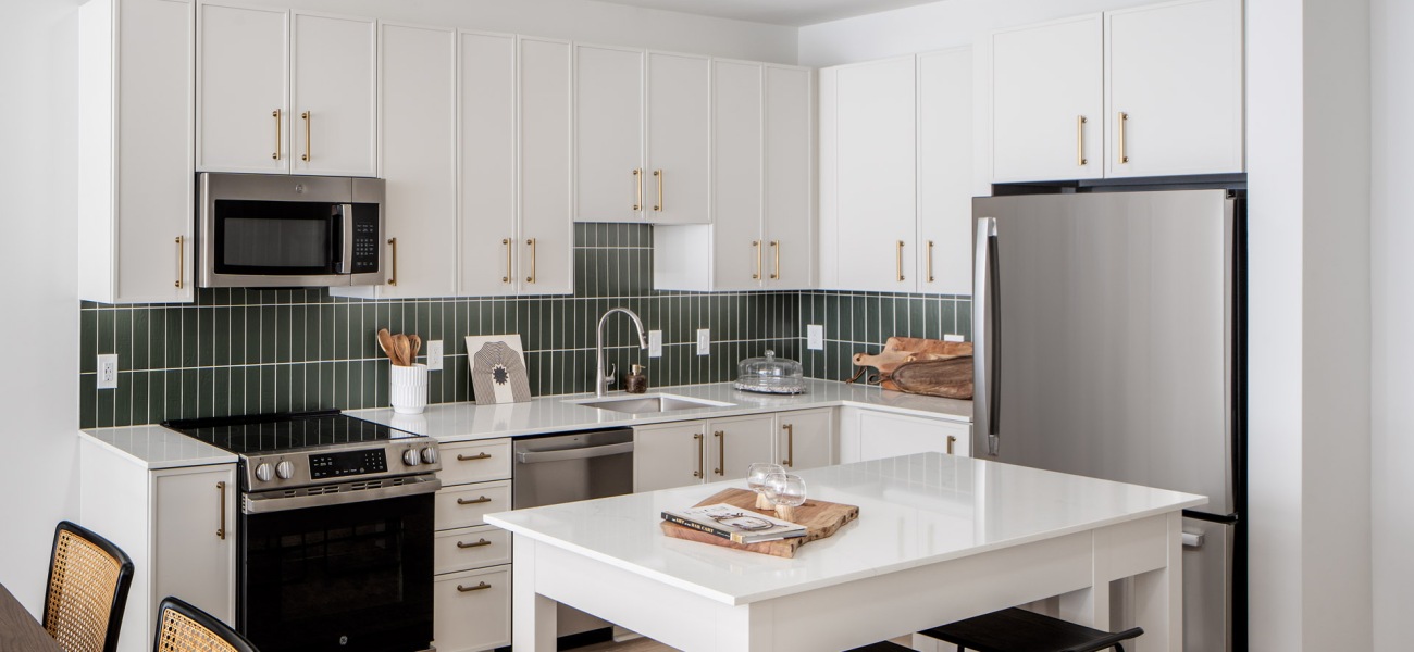 a bright kitchen with a island-table and seating